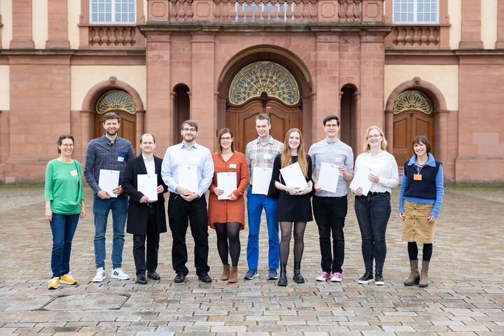 Lehr­ende, Mitarbeitenden und Studierende stehen mit ihren Zertifikaten zur Hochschuldidaktik auf dem Ehrenhof.