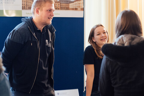 Mitarbeitende der Uni Mannheim informieren an einem Stand beim Studieninformationstag