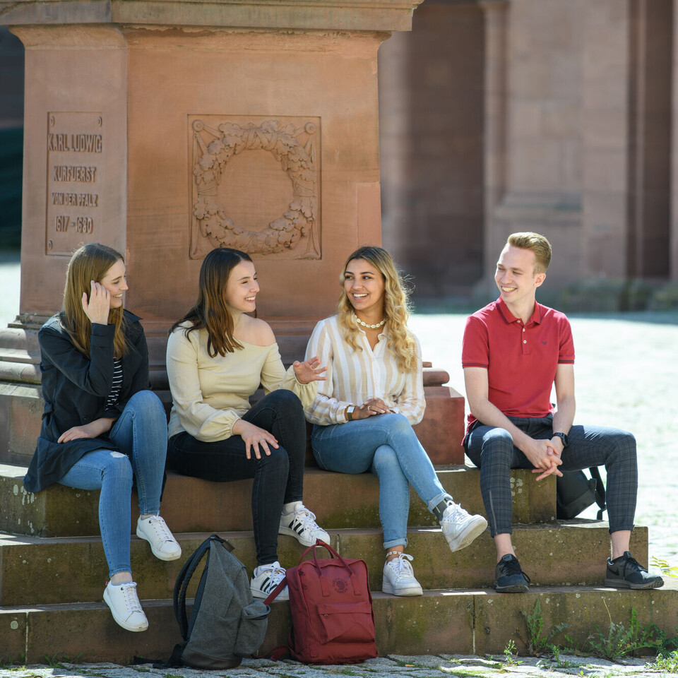 Vier Studierende vor Statue im Ehrenhof