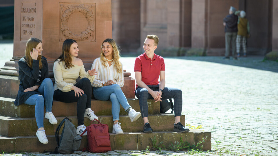 Vier Studierende vor Statue im Ehrenhof