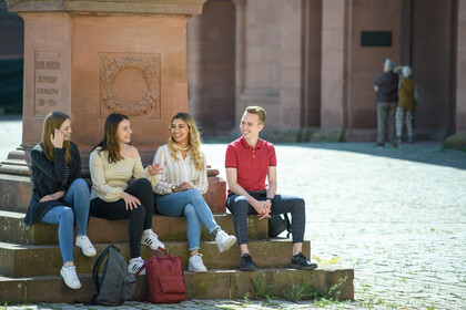Vier Studierende vor Statue im Ehrenhof