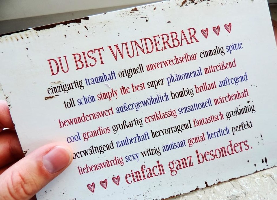 Ein Metallschild mit dem Titel "Du bist wunderbar" und der Unterschrift "einfach ganz besonder", dazwischen viele positiv konnotierte personenbezogene Adjektive wie "fantastisch", "einzigartig", "witzig".
