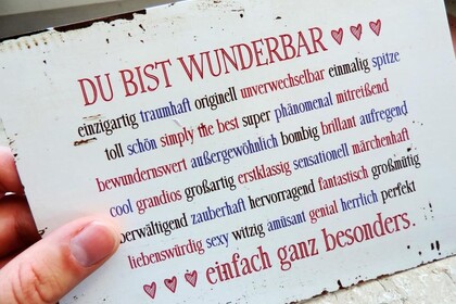 Ein Metallschild mit dem Titel "Du bist wunderbar" und der Unterschrift "einfach ganz besonder", dazwischen viele positiv konnotierte personenbezogene Adjektive wie "fantastisch", "einzigartig", "witzig".