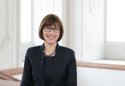 Prof. Dr. Annette Kehnel hat mittellange braune Haare und trägt eine Brille. Sie trägt einen dunklen Blazer.