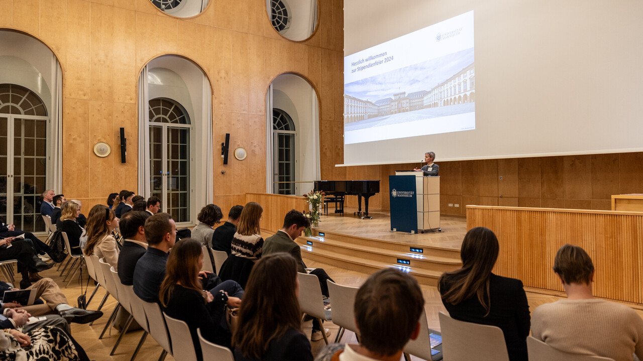 Viele Menschen hören einer vortragenden Person zu