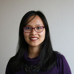 Linh Nguyen hat lange schwarze Haare. Sie trägt eine dunkle Brille und ein dunkles Oberteil.