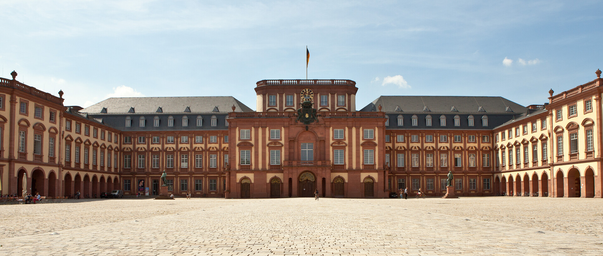 Das Mannheimer Barockschloss und der Ehrenhof unter blauem Himmel.