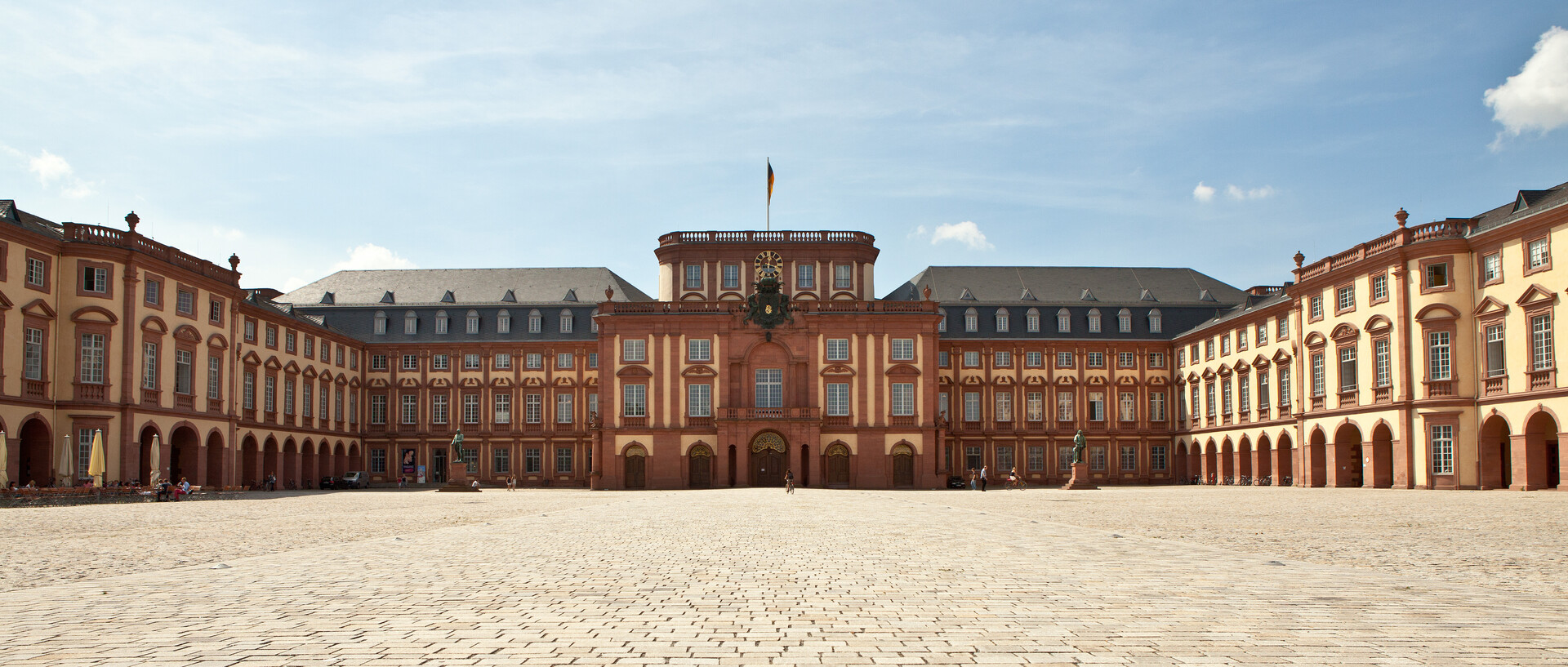 Das Mannheimer Barockschloss und der Ehrenhof unter blauem Himmel.