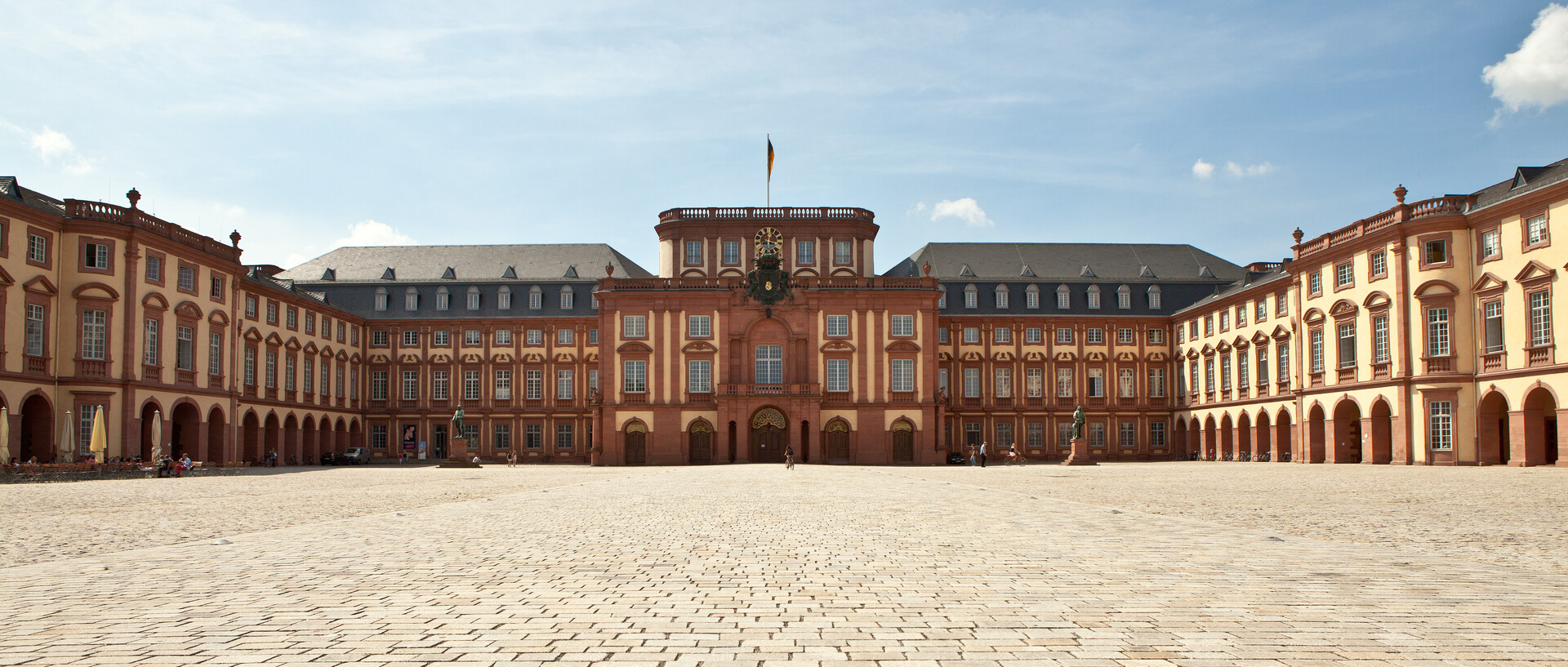 Das Mannheimer Barockschloss und der Ehrenhof unter blauem Himmel.