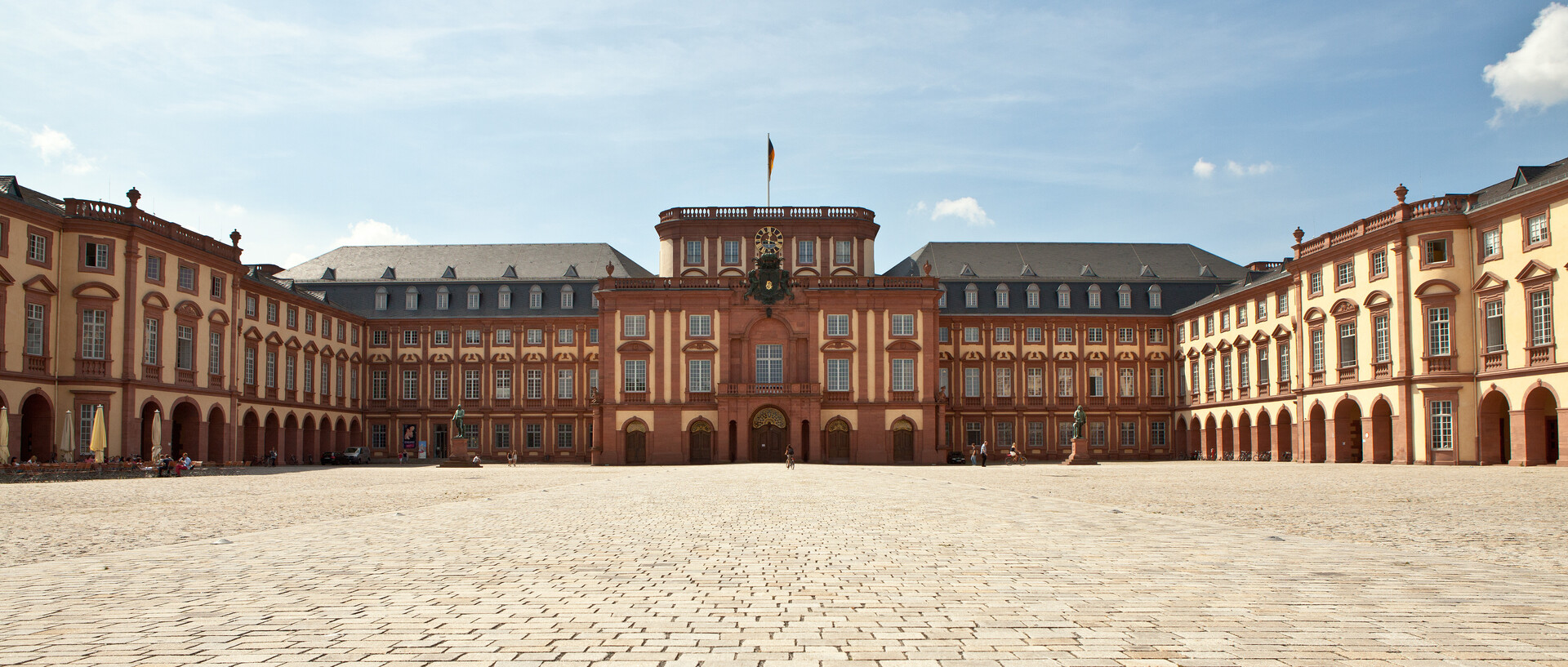 Das Mannheimer Barockschloss und der Ehrenhof unter blauem Himmel.