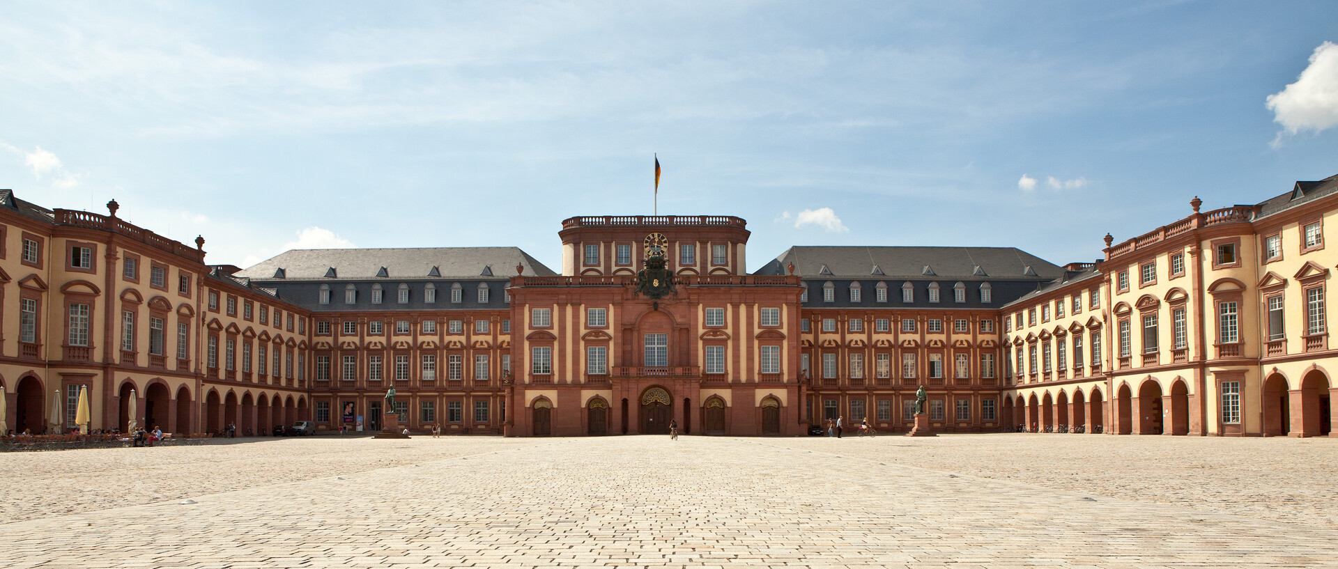 Das Mannheimer Barockschloss und der Ehrenhof unter blauem Himmel.