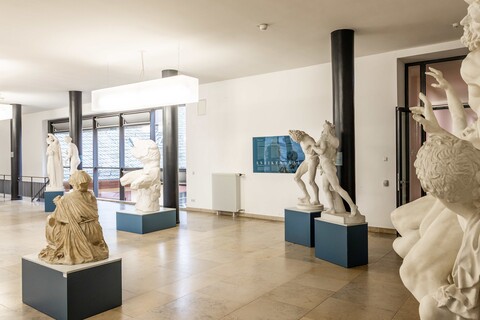 In einem Gang sind antike Skulpturen von Menschen ausgestellt.