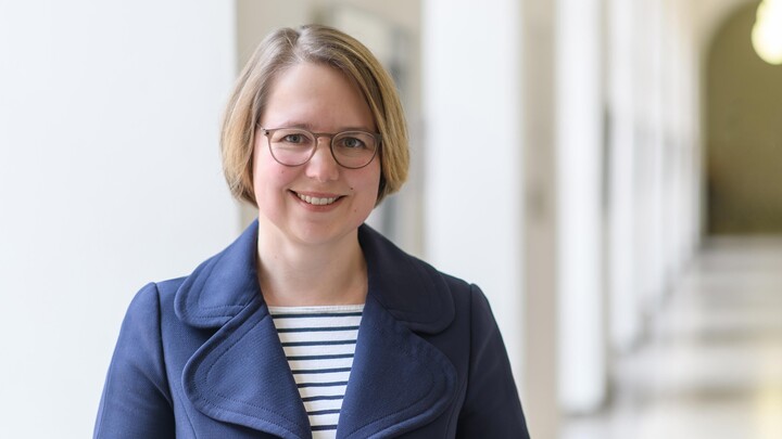 Portraitfoto von Prof. Dr. Karina Karst. Sie trägt ein blau-weiß gestreiftes Oberteil und einen blauen Blazer.