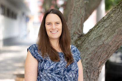 Portrait von Beatrice Kuhlmann. Sie trägt ein blau-weiß gemustertes Oberteil.