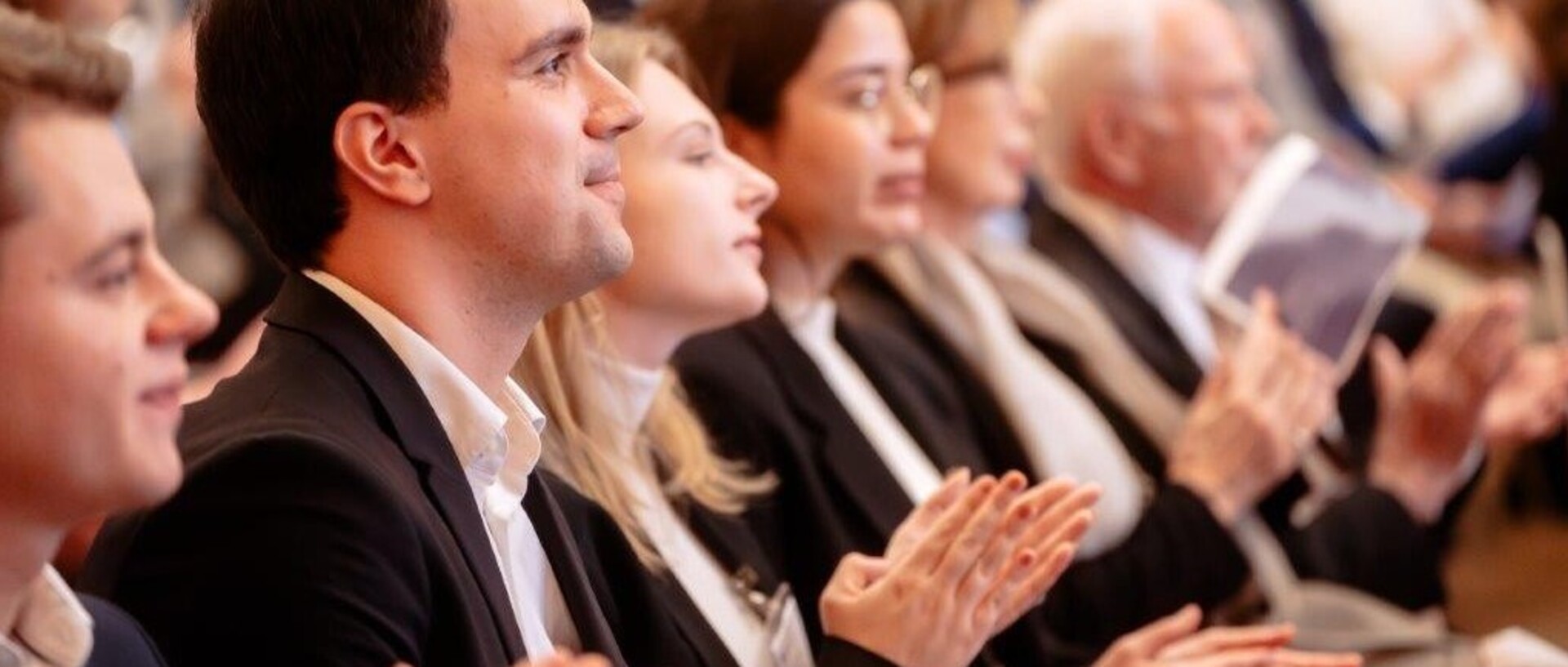 Zuhörer in der Aula applaudierend