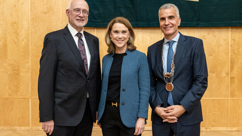 Prof. Dr. Thomas Puhl (links), Ministerin Petra Olschowski und Prof. Dr. Thomas Fetzer (rechts) bei der Rektoratsübergabe, während sie lächelnd nebeneinander stehen.
