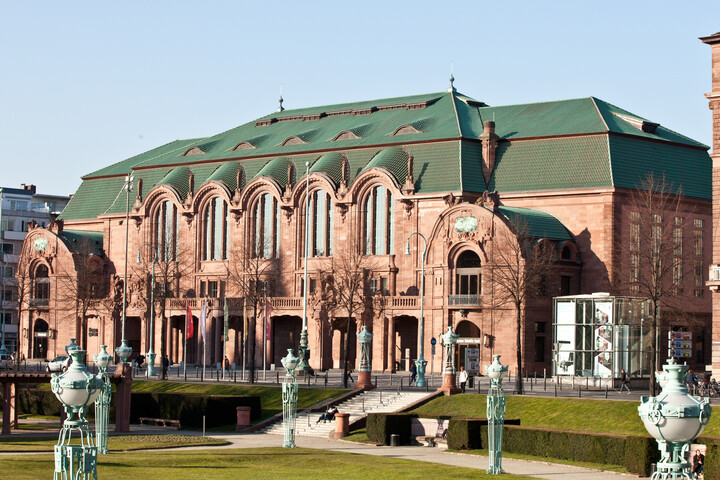 Ein großes, helles Gebäude mit grünem Dach.