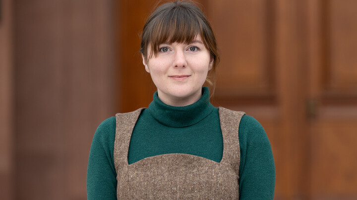 Portrait of Laura Young with green top in front of a door