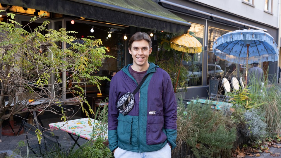 Ein sportlich gekleideter Student vor einem Café in der Schwetzinger Vorstadt