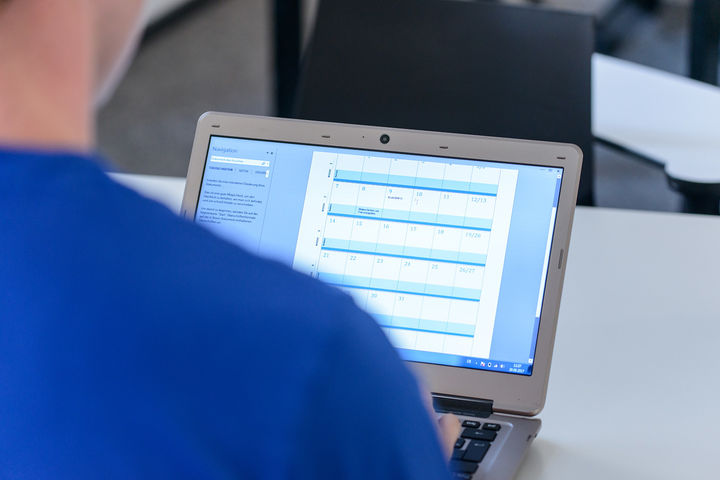Eine Person hat einen Kalender auf dem Laptop geöffnet.
