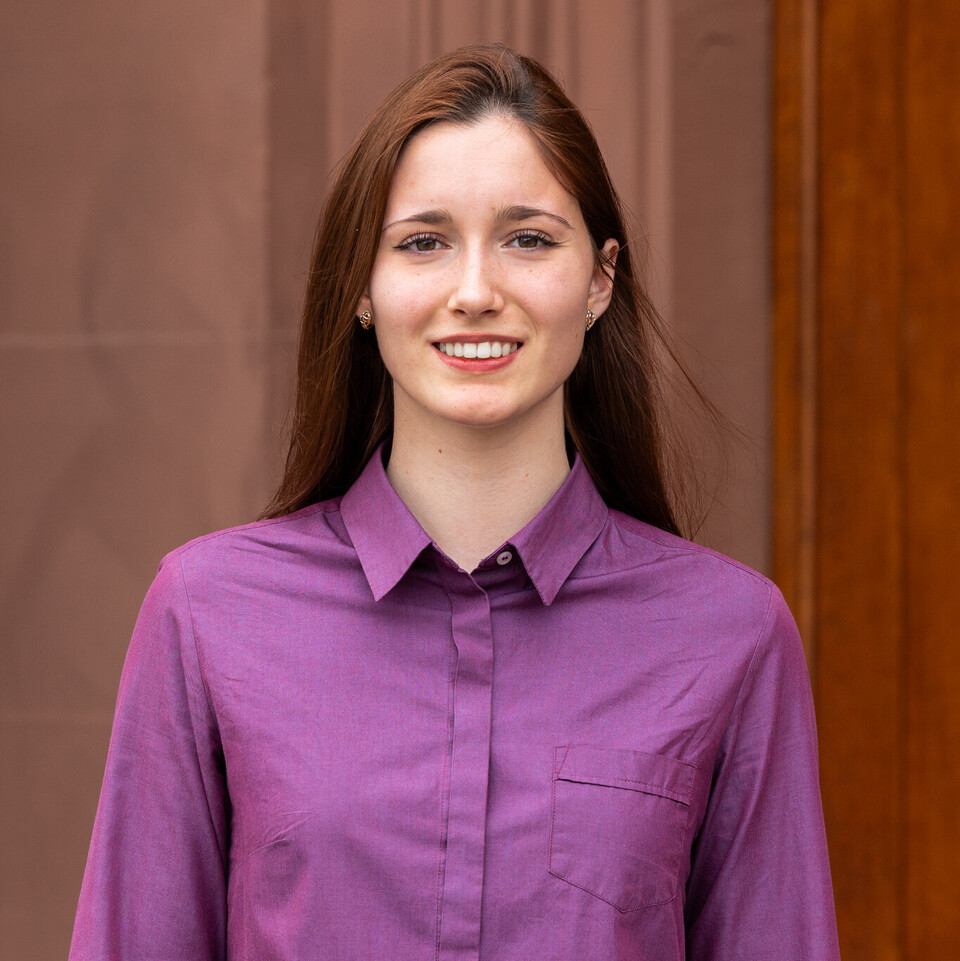 Kseniia Gorokhovska trägt eine lila Bluse.