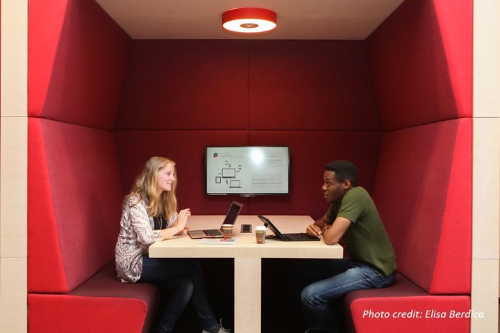 Eine Studentin und ein Student lernen gemeinsam in einer roten Nische im Learning Center der Universität Mannheim.