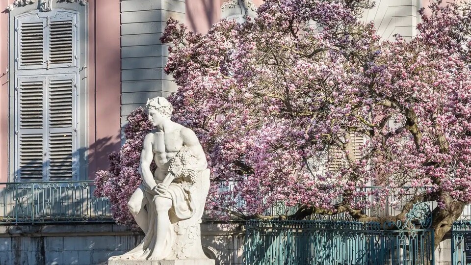 Eine Statue steht vor einem Schloss