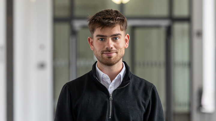 Luca di Leo wearing a white shirt and a black sweater.