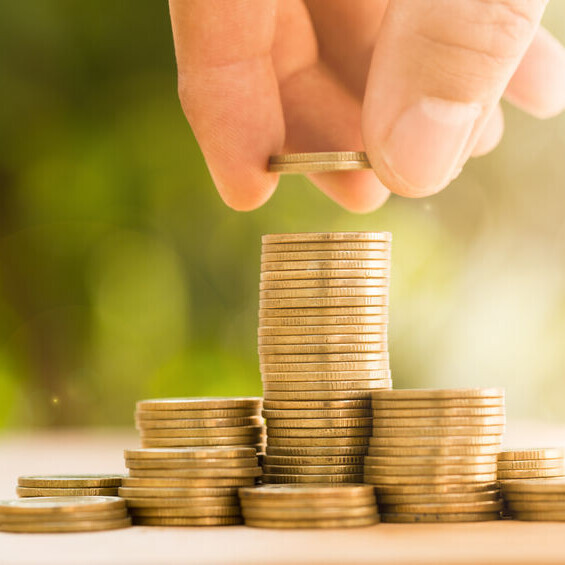 Eine Person stapelt Münzen aufeinander.