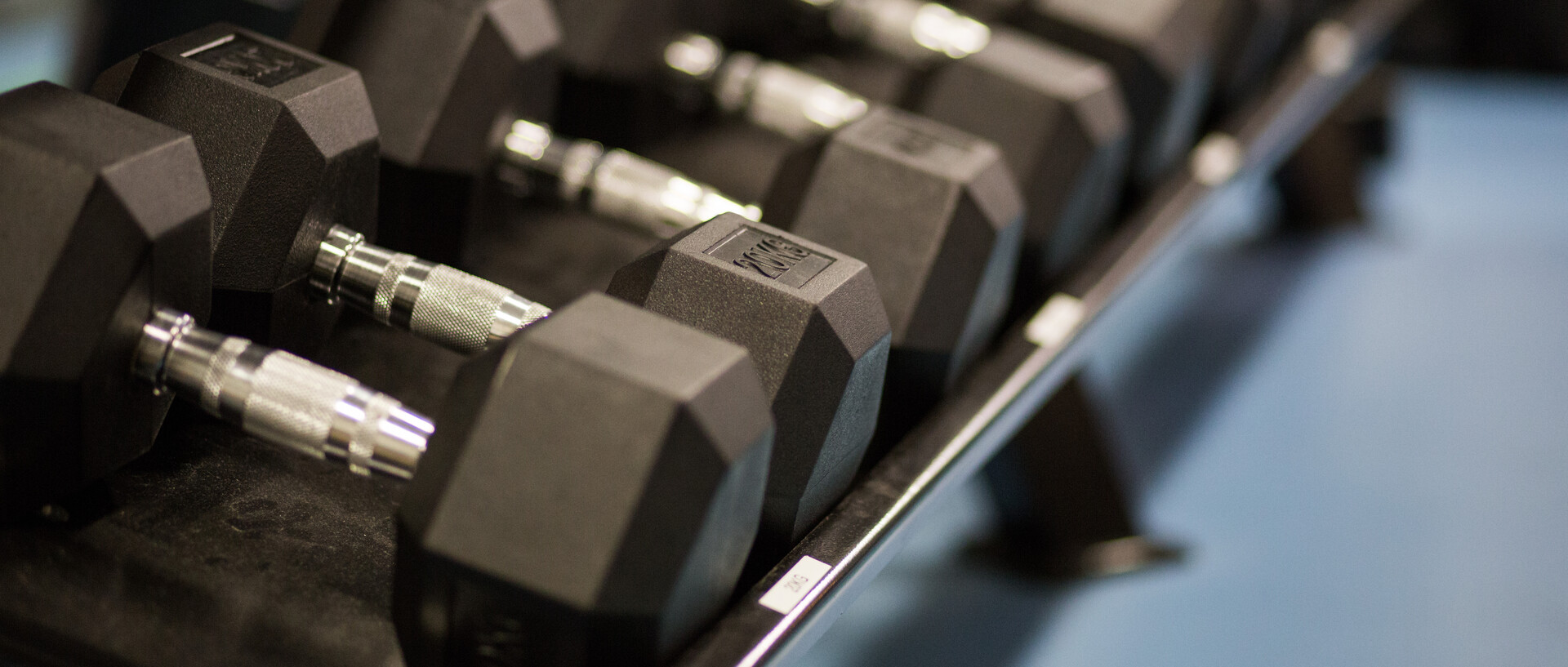 Schwarze Kurzhanteln auf einer Hantelbank aufgereiht