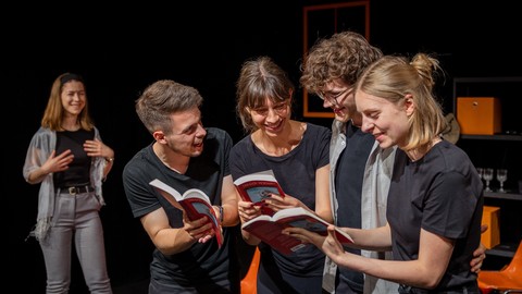 Theaterspielende lesen in Büchern.