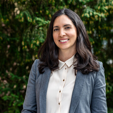 Karla Funes. Karla Funes lächelt und trägt einen blauen Blazer sowie eine weiße Bluse.
